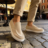 Beige suede slip-on loafers, close-up side view with low white sole