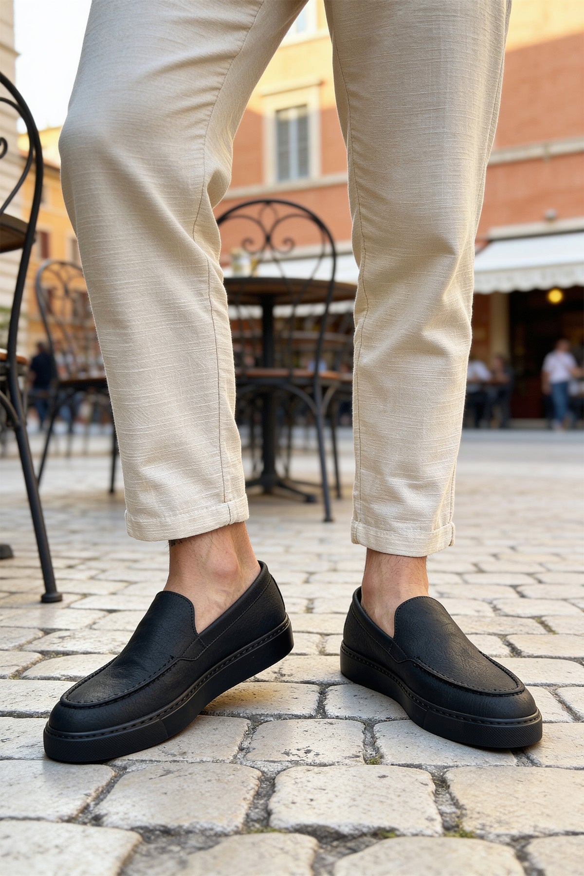 Men's black slip-on loafers, side profile with low stacked heel