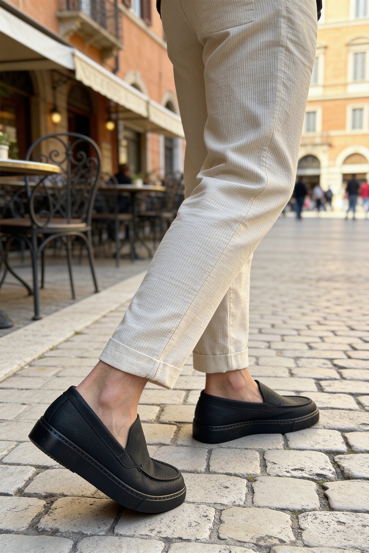 Men's black slip-on loafers, front angle with visible seam detail