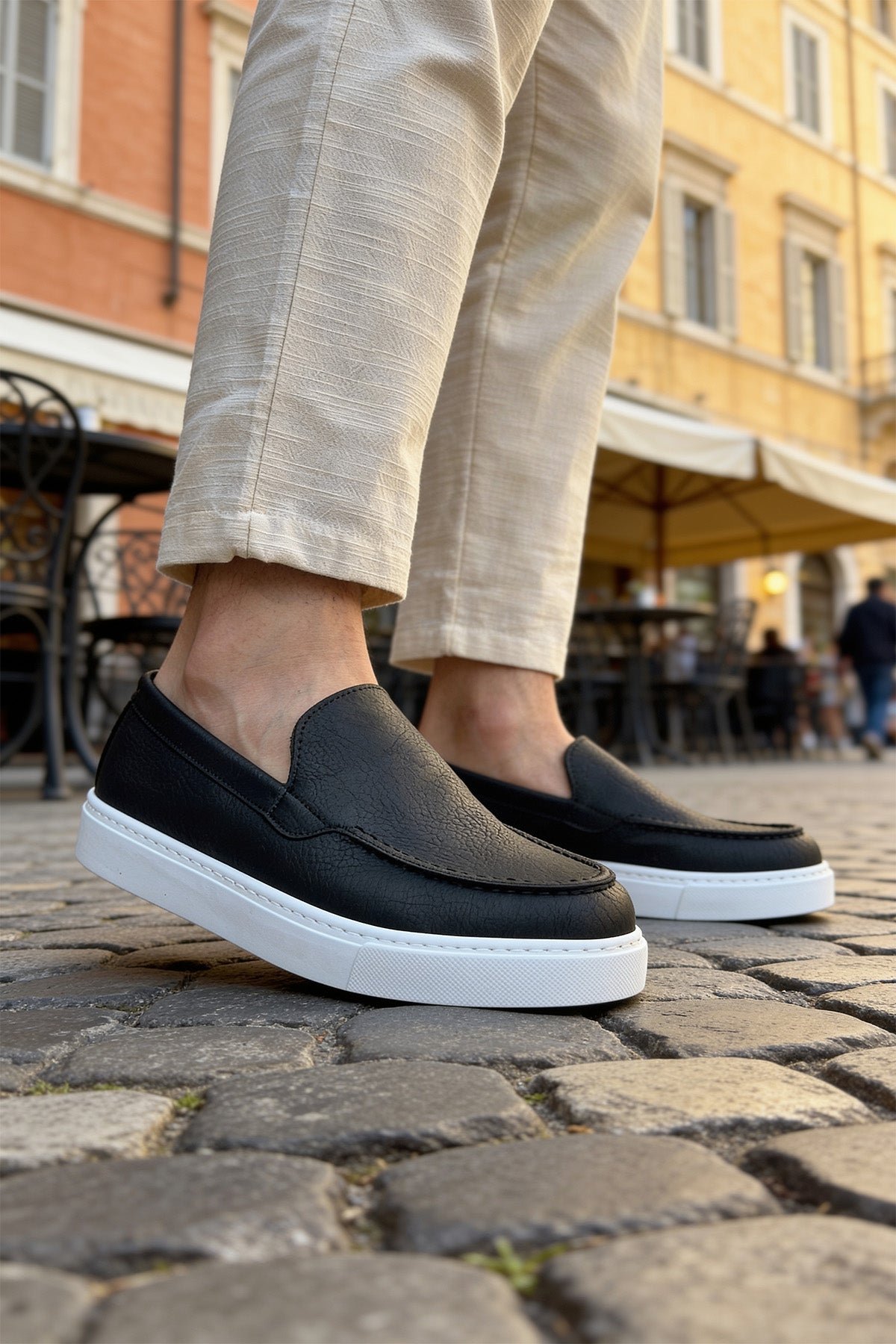 Black loafers with white soles, side profile on casual slip-on shoes