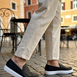 Black slip-on loafers with white soles, low-profile casual shoes
