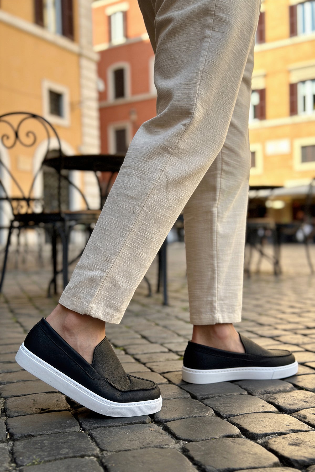 Black slip-on loafers with white soles, low-profile casual shoes