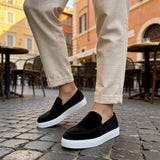 Black suede slip-on loafers with white sole and simple top seam