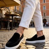 Black suede loafers with white rubber sole, side slip-on opening