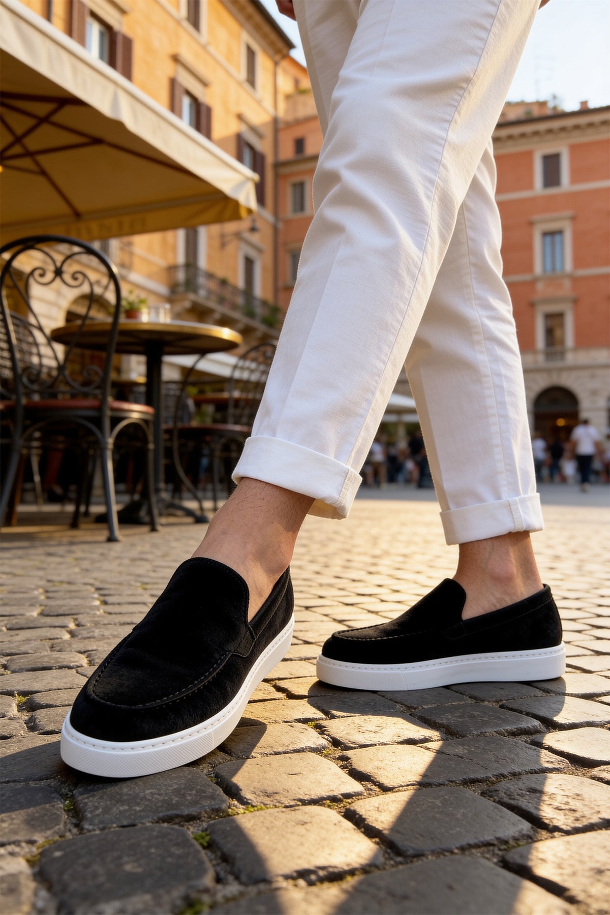 Black suede loafers with white rubber sole, side slip-on opening