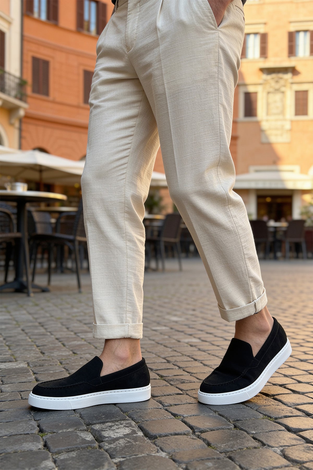 Black suede slip-on loafers with white sole and minimal stitched panels