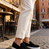 Black suede loafers with white sole, rounded toe slip-on style