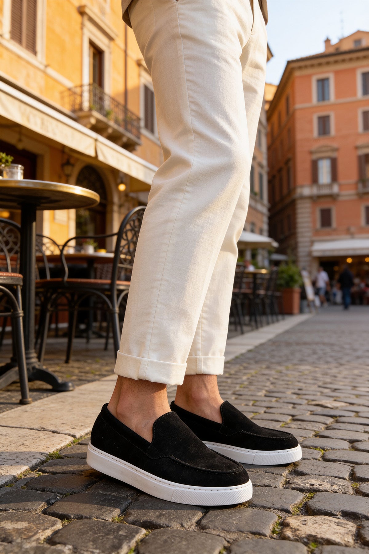 Black suede loafers with white sole, rounded toe slip-on style