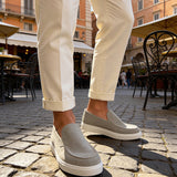 Men's gray suede loafers with side cutout detail and white rubber sole