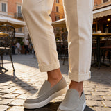 Men's gray suede loafers, slip-on design with stitched apron and white rubber sole