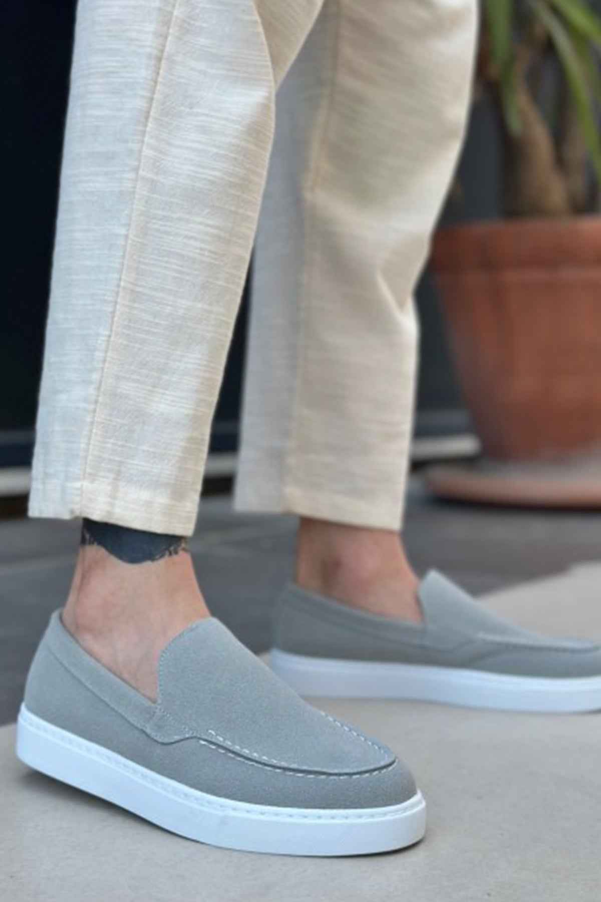 Men's gray suede loafers, slip-on design with white rubber sole and stitched vamp