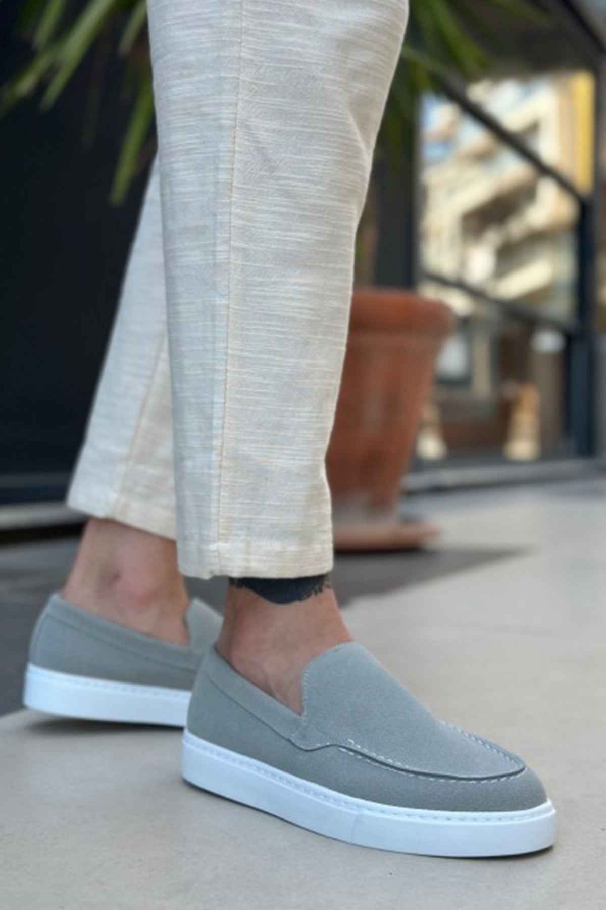 Men's gray suede loafers with moc-toe stitching and white rubber slip sole