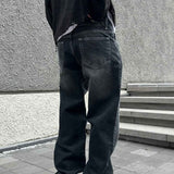 Dark charcoal baggy jeans, back view with patch pockets and relaxed straight legs