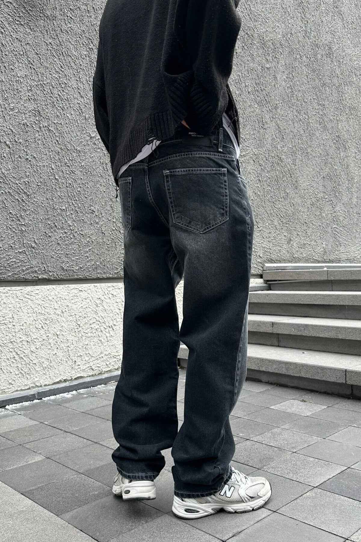 Dark charcoal baggy jeans, back view with patch pockets and relaxed straight legs
