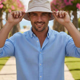 Beige bucket hat with wide brim, Ritar, held by a man in a blue shirt