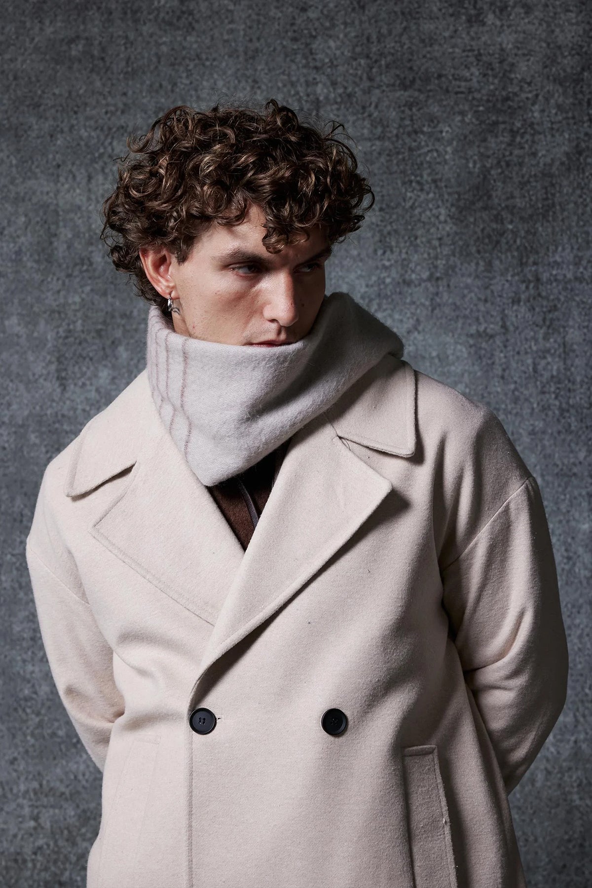 Men's oversized beige coat close-up: wide lapels, double-breasted buttons, front pockets