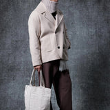 Men's oversized light beige double-breasted coat with wide lapels and patch pockets