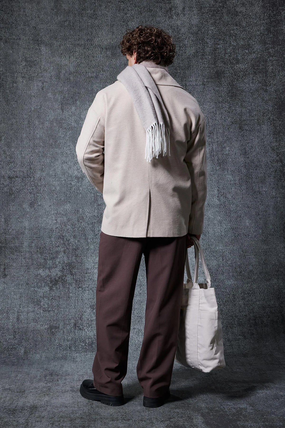 Men's oversized light beige coat, back view with center seam and standing collar