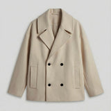 Light beige double-breasted coat with peaked lapels, dark buttons, and two patch pockets