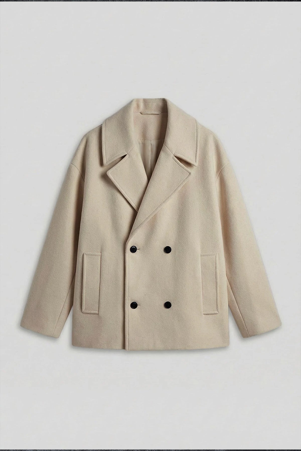 Light beige double-breasted coat with peaked lapels, dark buttons, and two patch pockets