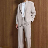 Men's beige oversized suit, side view: blazer with pockets and matching trousers