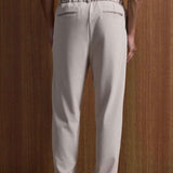 Beige oversized suit trousers, back view with elastic waistband and side pockets
