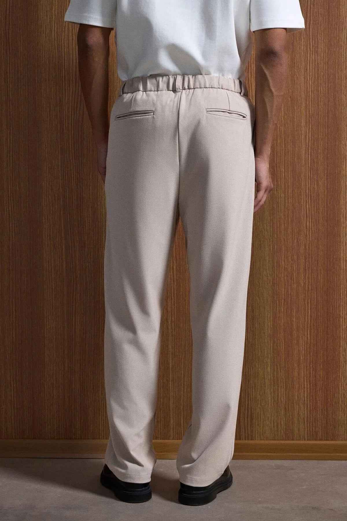 Beige oversized suit trousers, back view with elastic waistband and side pockets