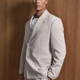 Men's beige oversized suit, angled view: blazer with chest pocket and trousers