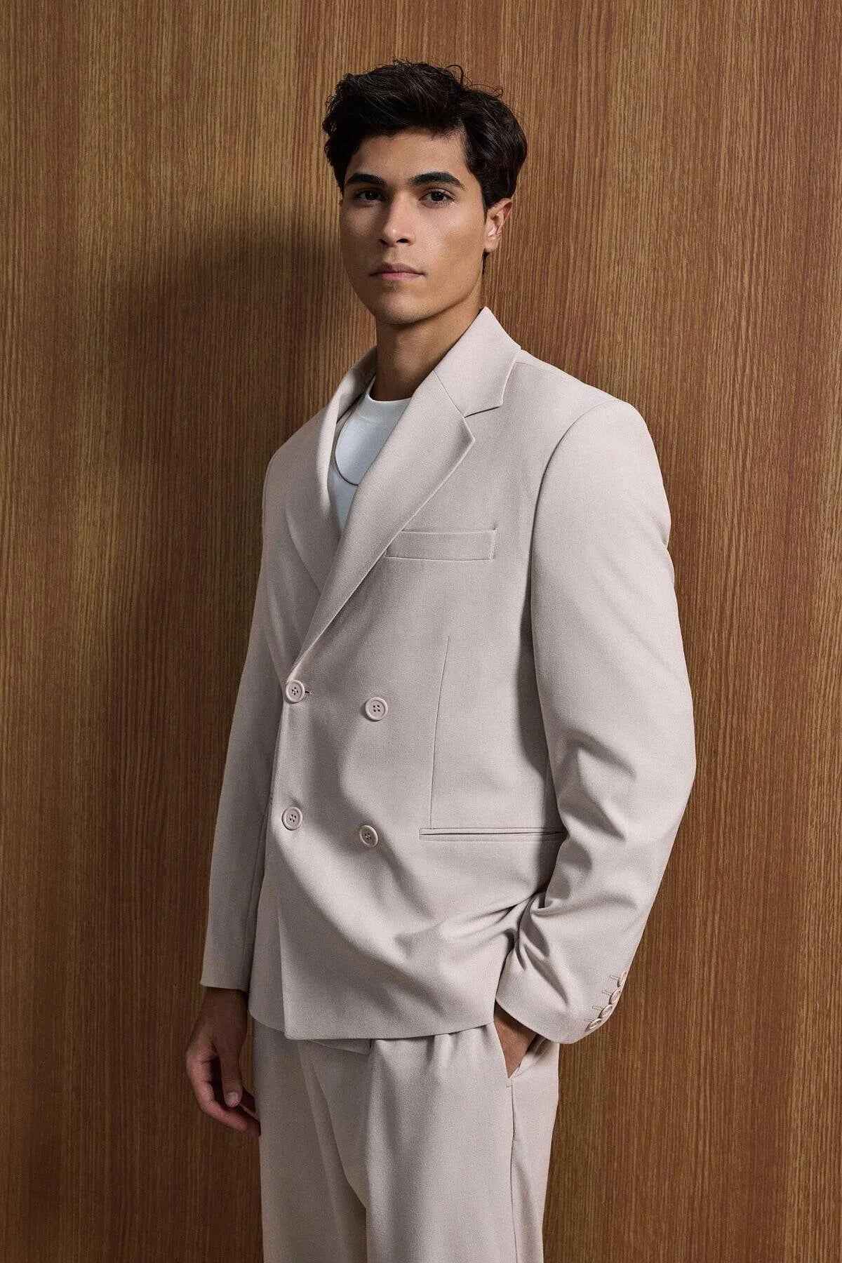 Men's beige oversized suit, angled view: blazer with chest pocket and trousers