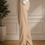 Men's beige tailored pants with black belt, relaxed straight leg, side view