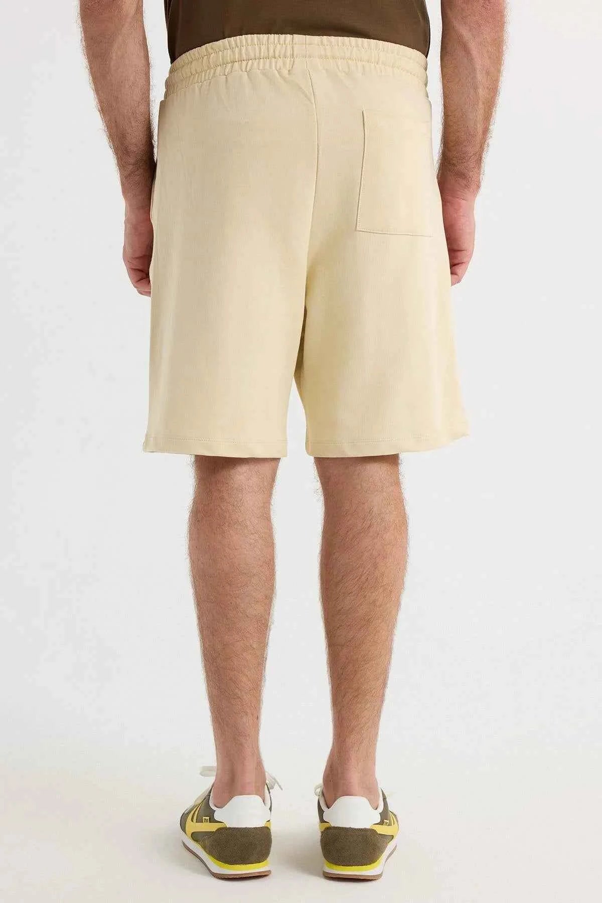 Men's light beige shorts with elastic waistband and knee-length cut