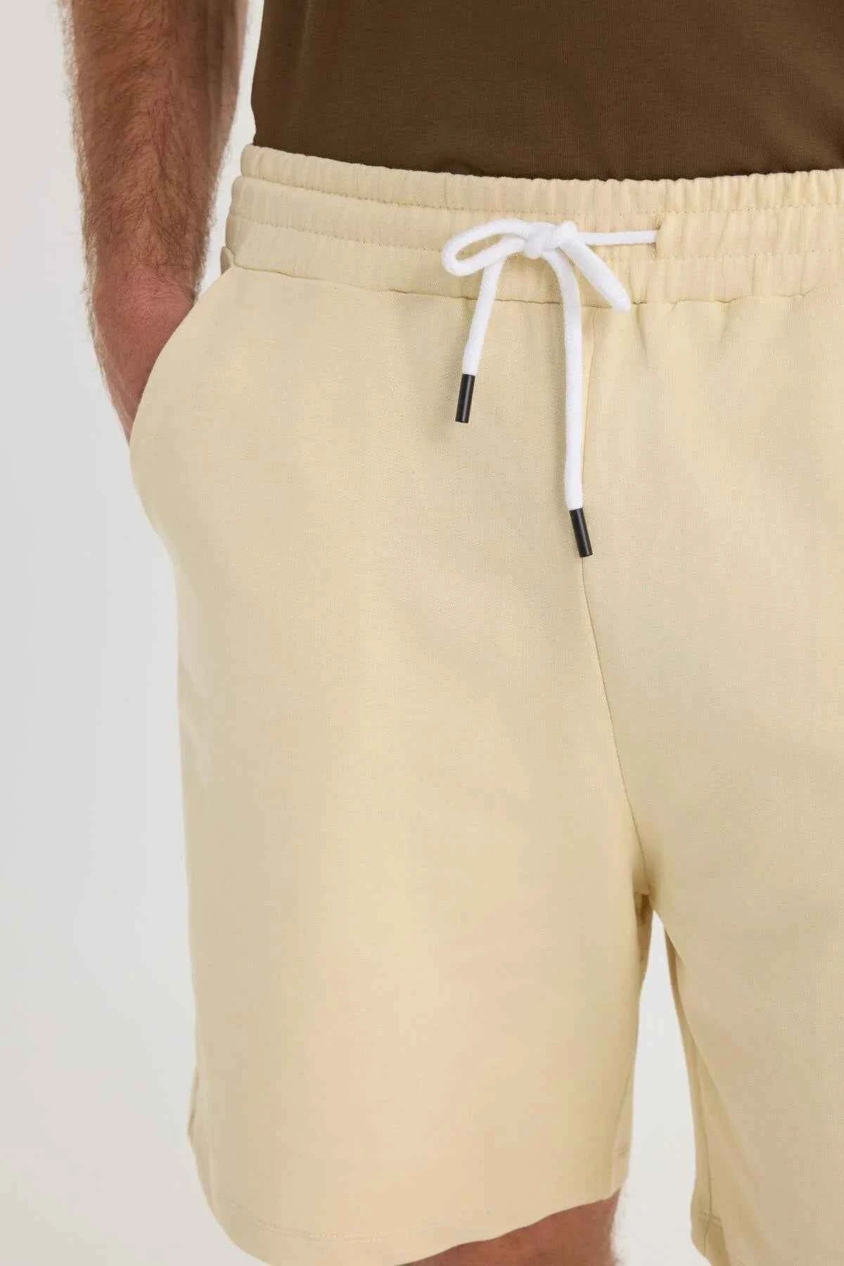 Men's light beige shorts close-up: elastic waistband and white drawstring