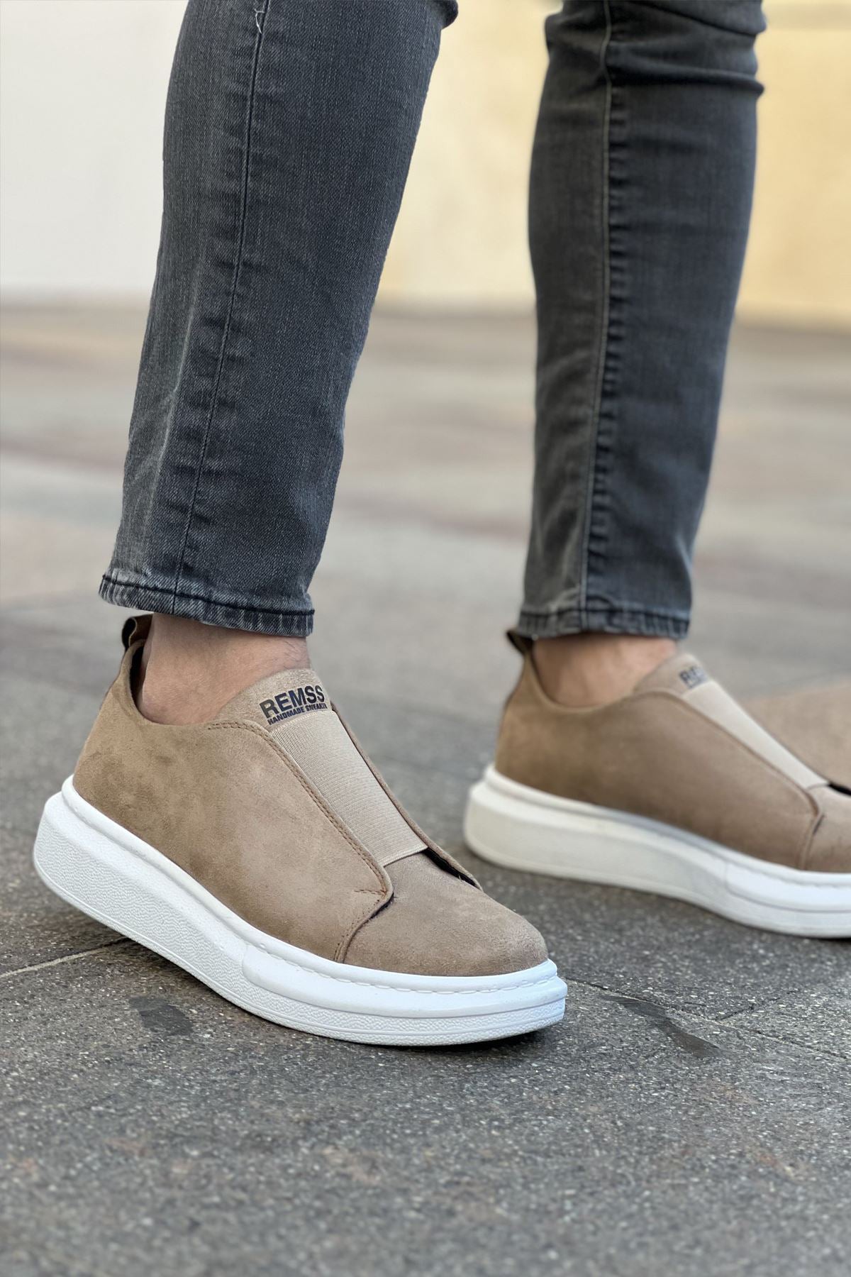 Pair of beige low-top slip-on sneakers with white rubber soles, side view