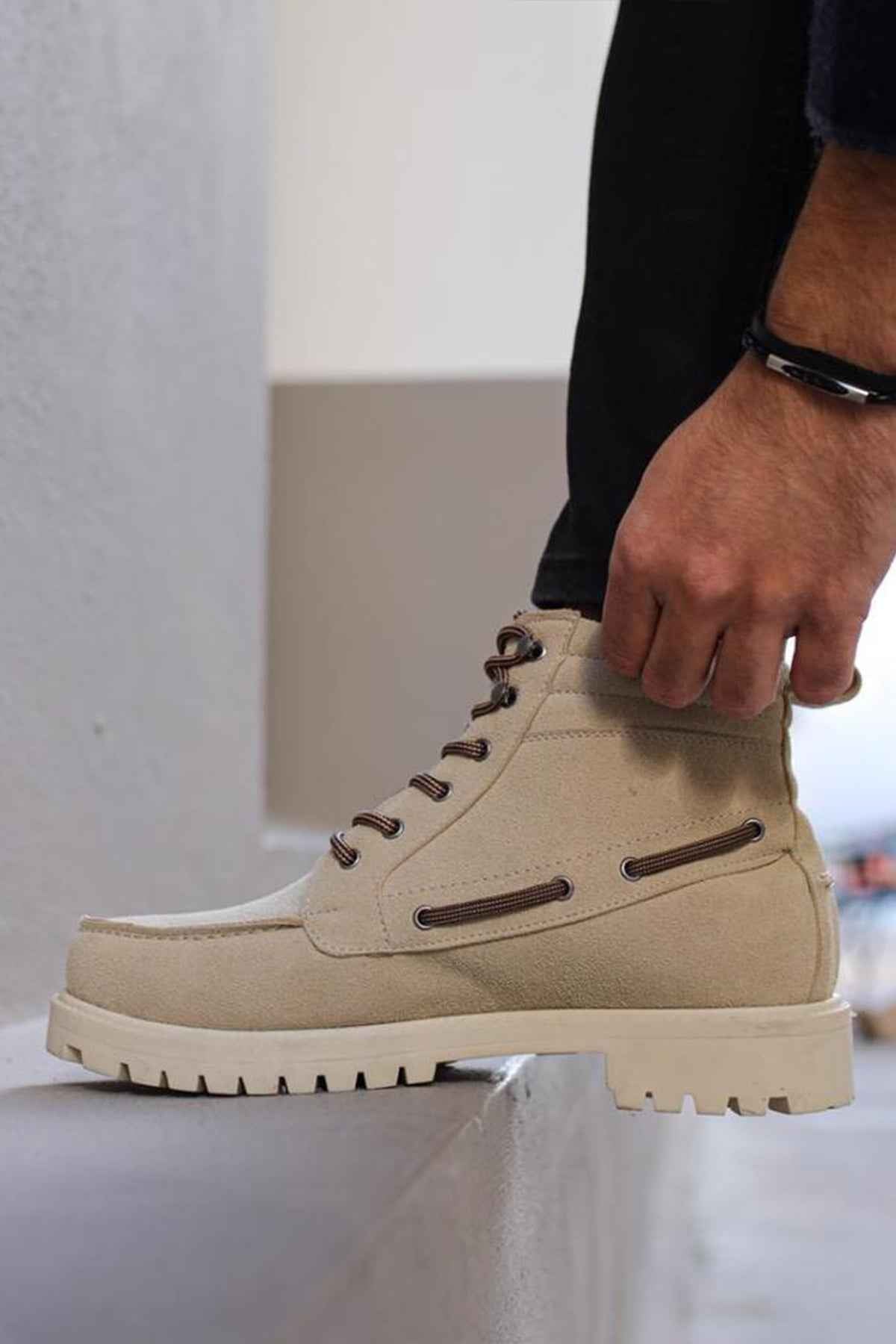 Beige suede lace-up boots showing side profile, padded collar, and lug sole