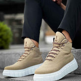Beige suede lace-up boots with white platform sole, worn with dark pants