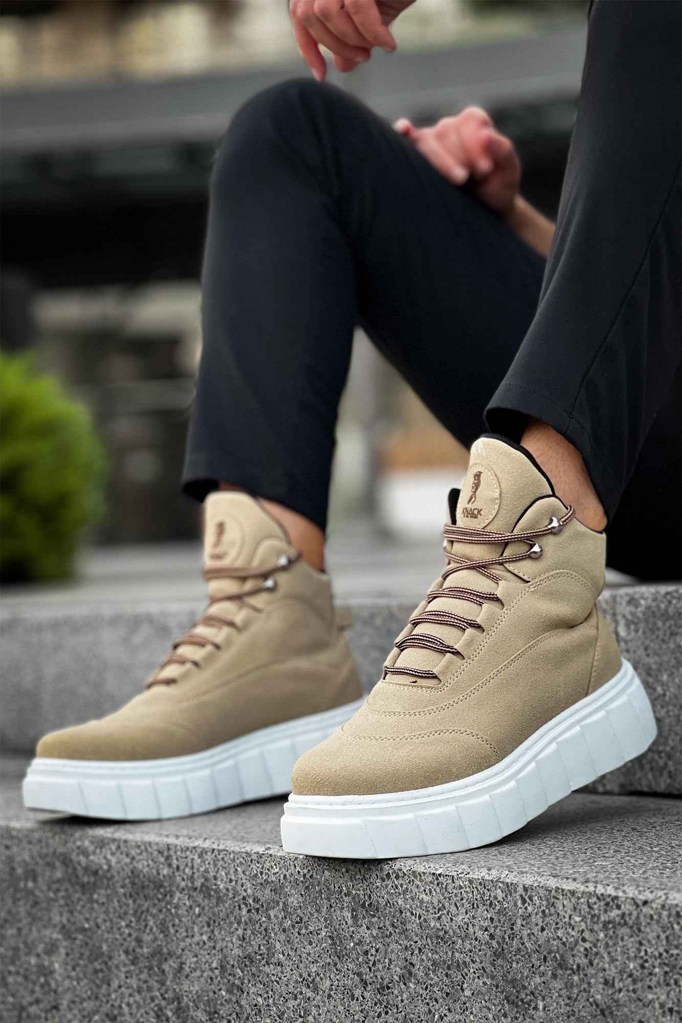 Beige suede lace-up boots with white platform sole, worn with dark pants