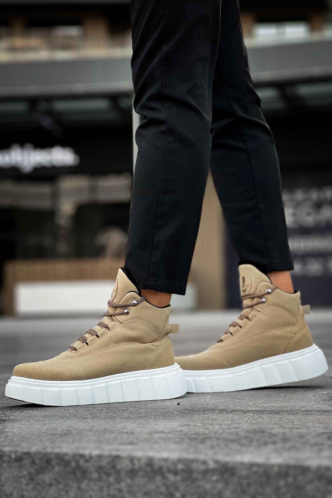 Beige suede lace-up platform boots with white sole, side view on pavement