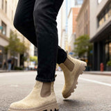 Men's beige suede Chelsea boots with side elastic and lug sole, ankle height.