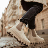 Men's beige suede boots with side elastic and thick lug sole, close-up.