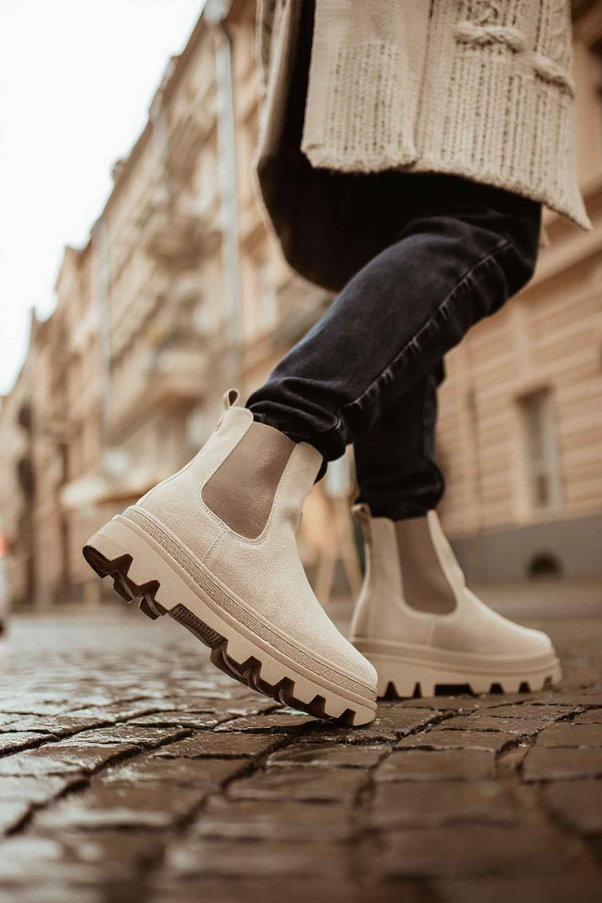 Men's beige suede boots with side elastic and thick lug sole, close-up.