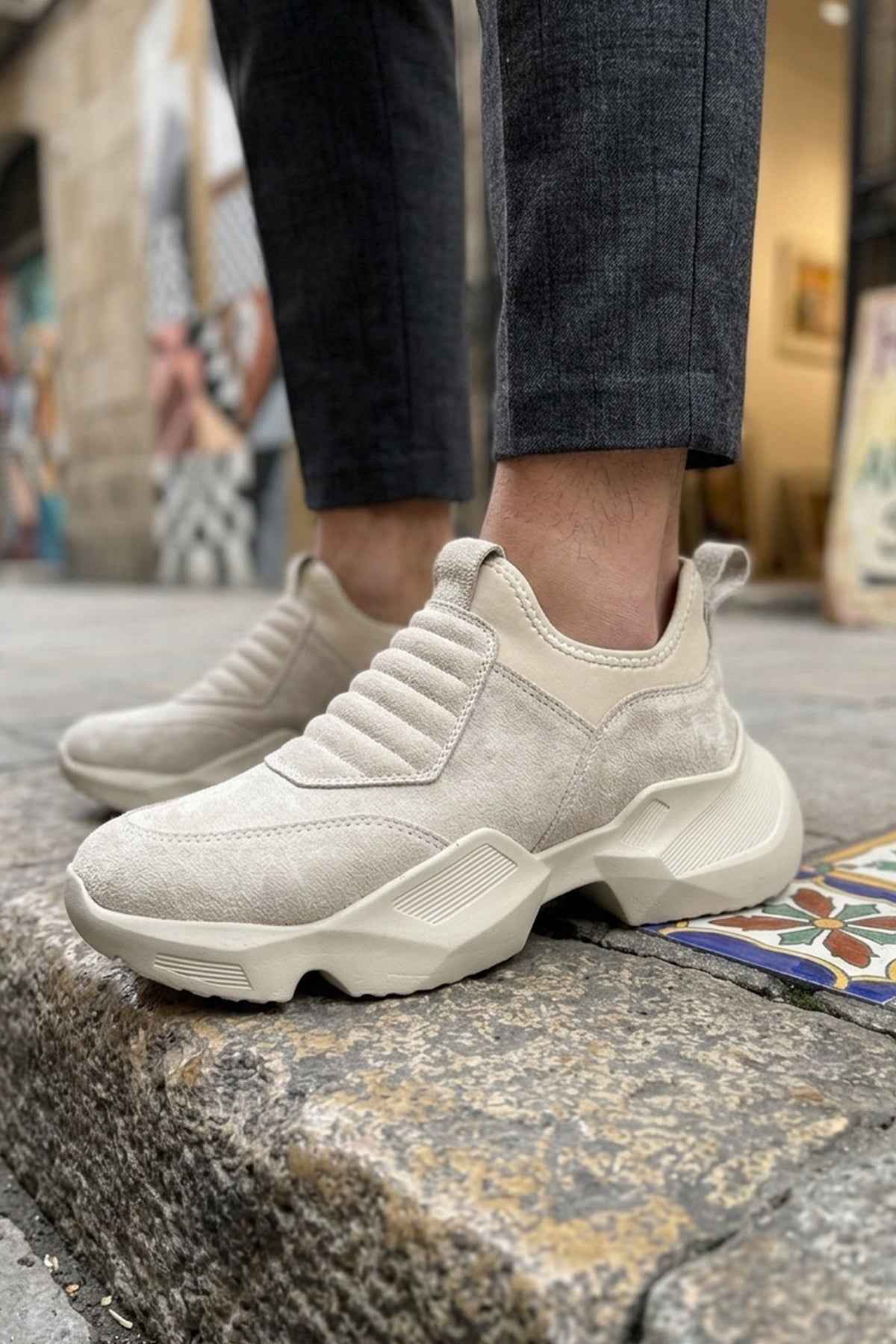 Beige suede slip-on sneakers with chunky white sole and textured side panels