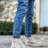 Beige suede low-top sneakers with lace-up closure and thick ridged rubber sole