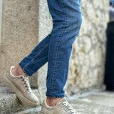 Beige suede sneakers with lace-up front and textured rubber sole, angled view