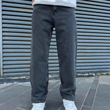 Men's baggy dark jeans standing front view, straight relaxed legs