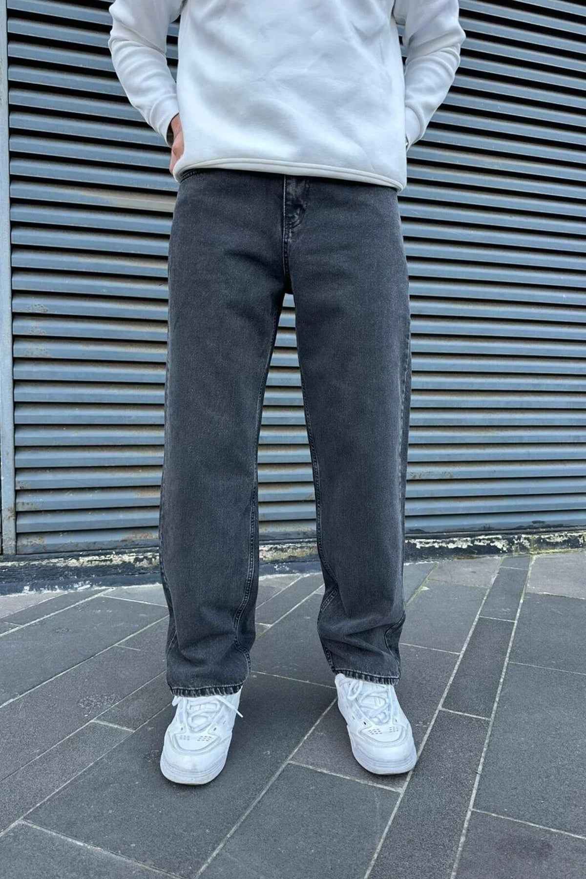 Men's baggy dark jeans standing front view, straight relaxed legs