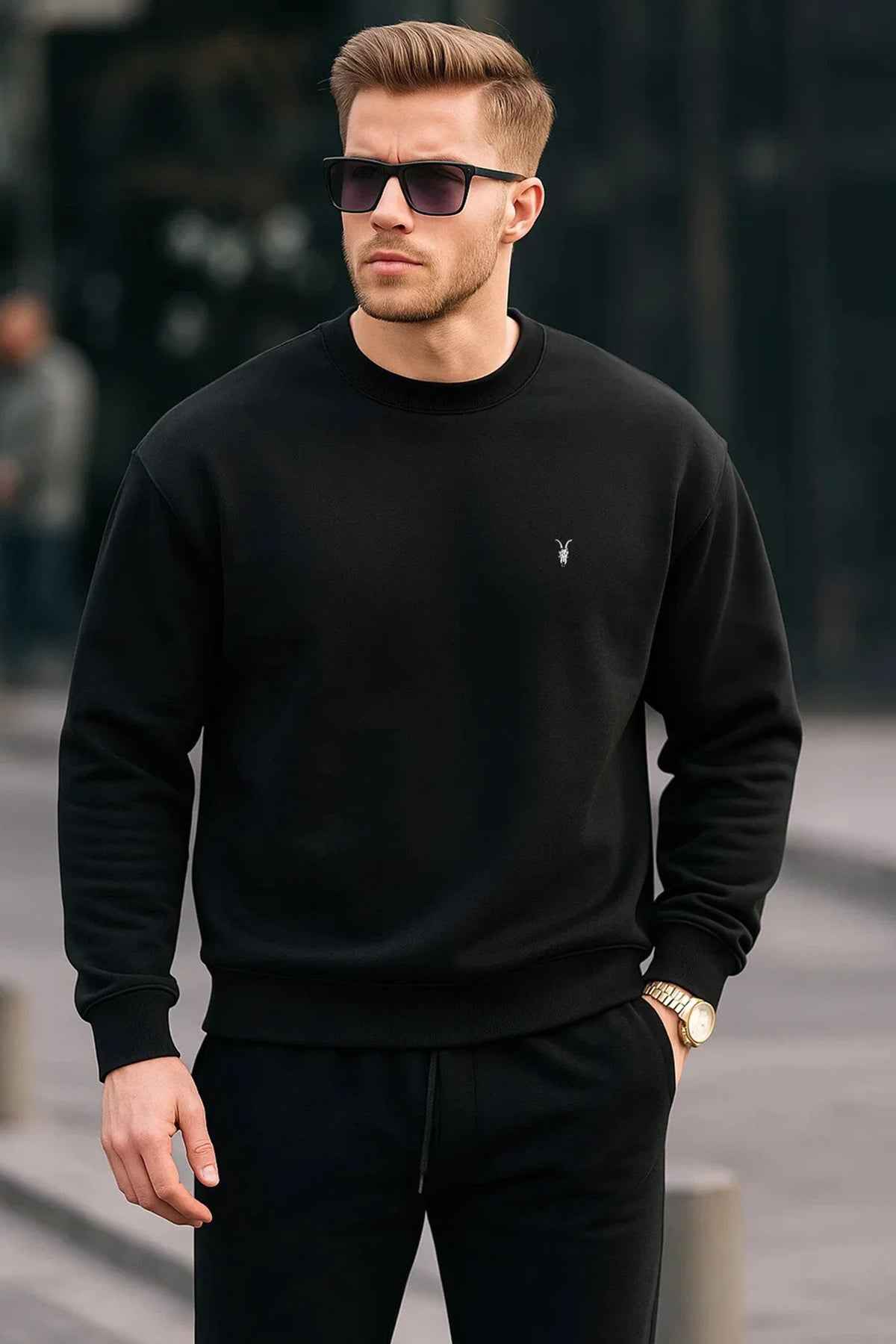 Black crewneck sweatshirt with small chest logo, ribbed cuffs and hem