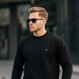 Black crewneck sweatshirt, long sleeves, ribbed cuffs, small chest logo
