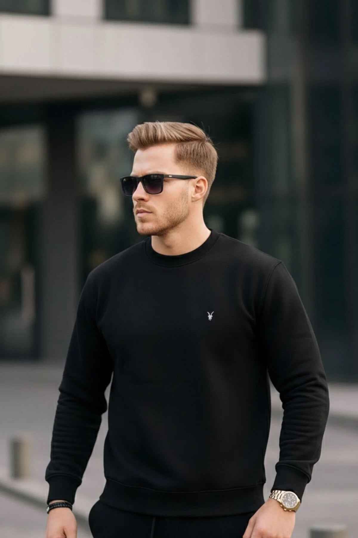 Black crewneck sweatshirt, long sleeves, ribbed cuffs, small chest logo