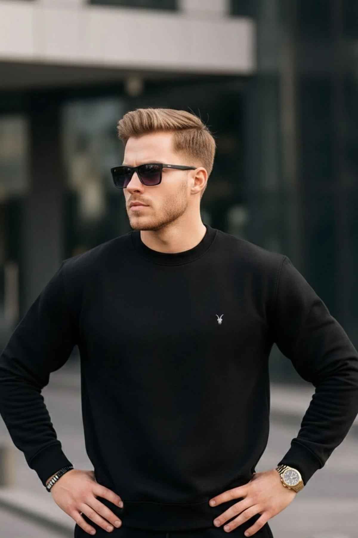 Black crewneck sweatshirt with ribbed cuffs and hem, small chest logo on chest