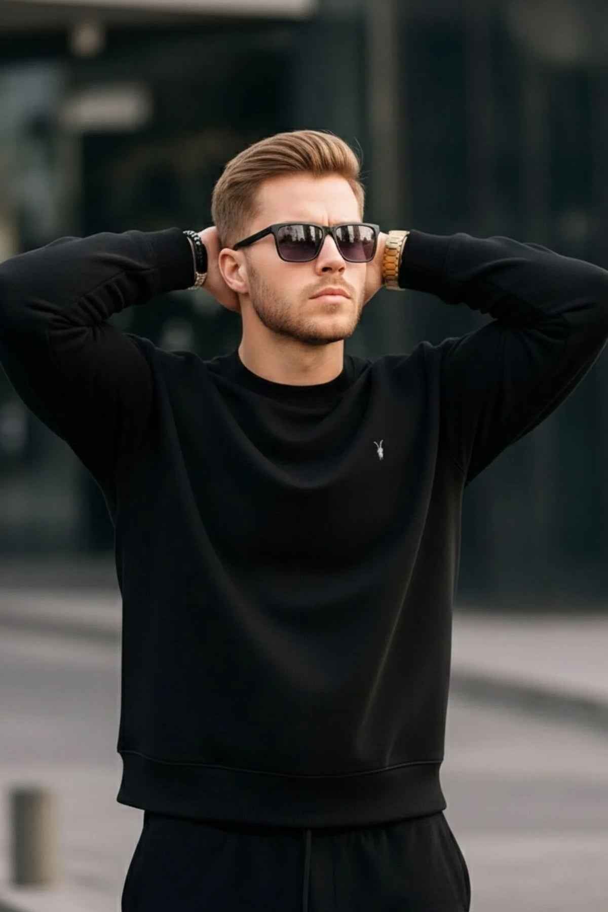 Black crewneck sweatshirt, ribbed cuffs and hem, small chest logo at center